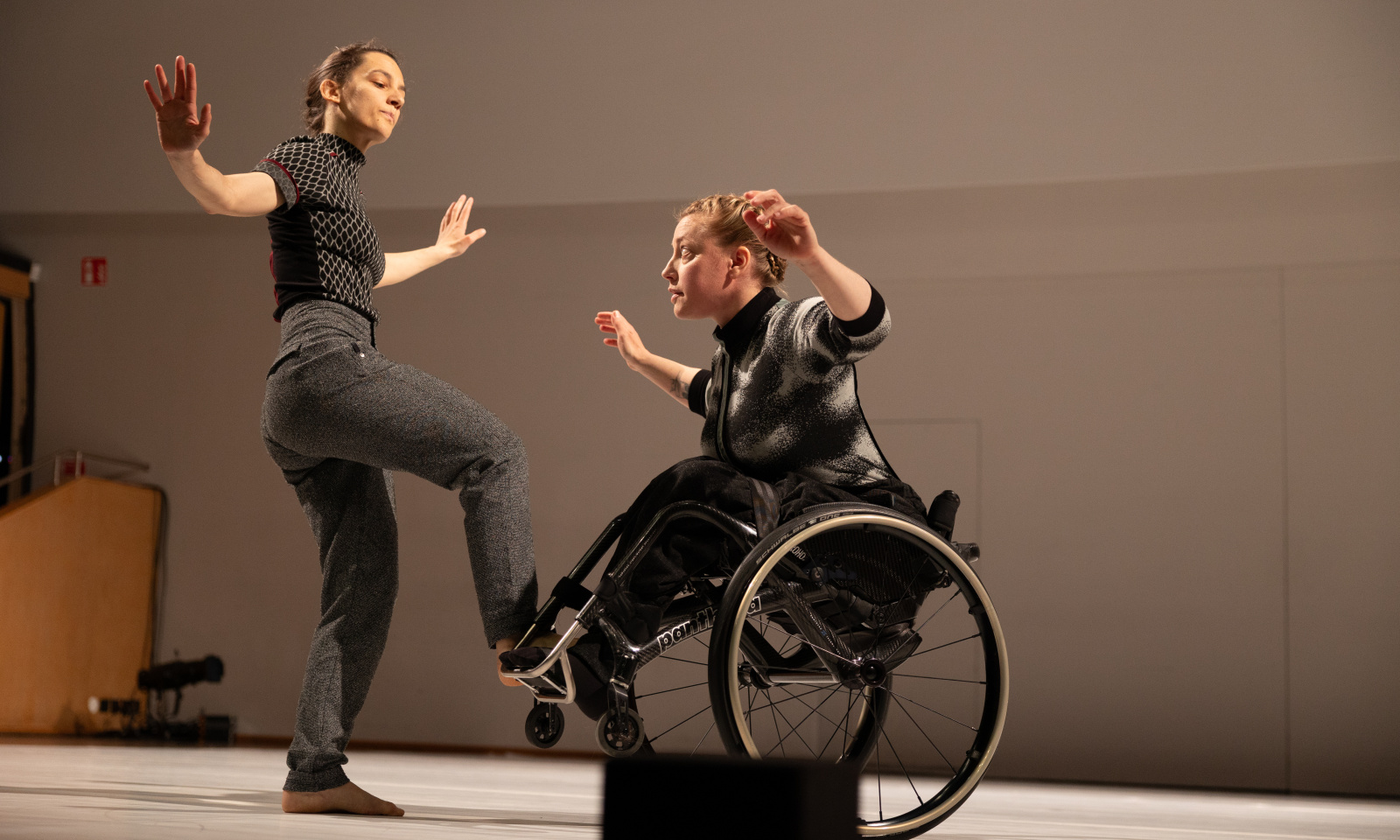 Two dancers, where one is using a wheelchair