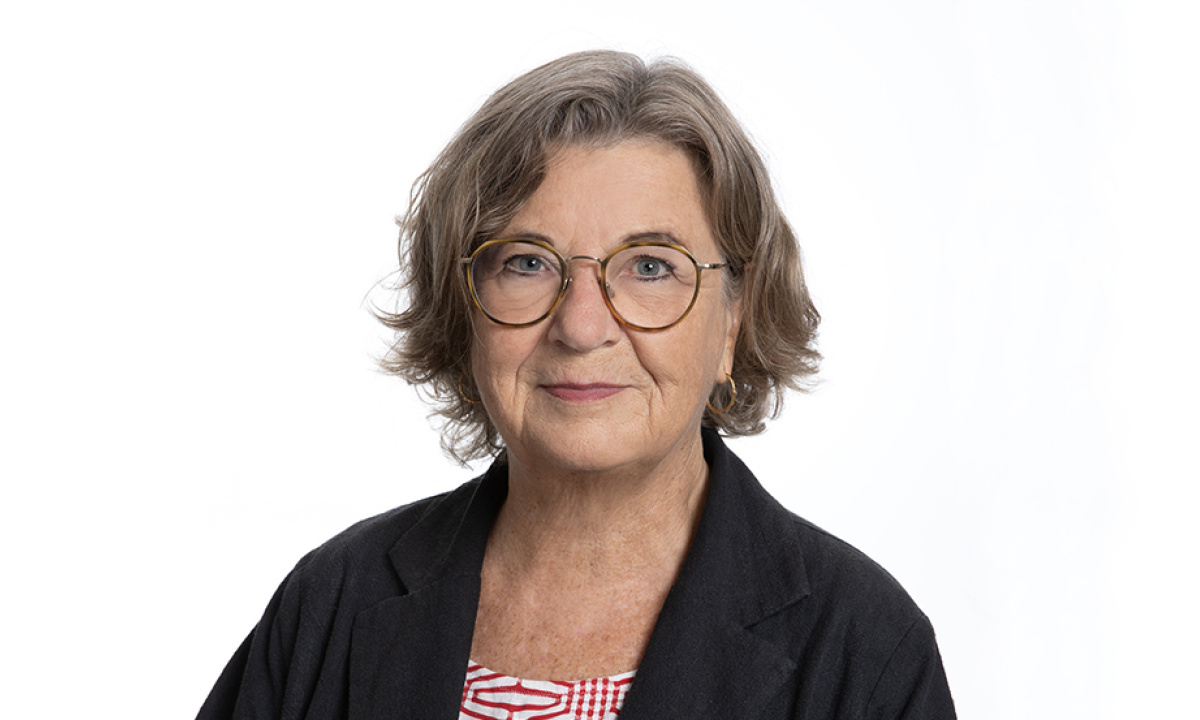 Wommen around 70 with light skin, glasses, dark blone hair with a black jacket