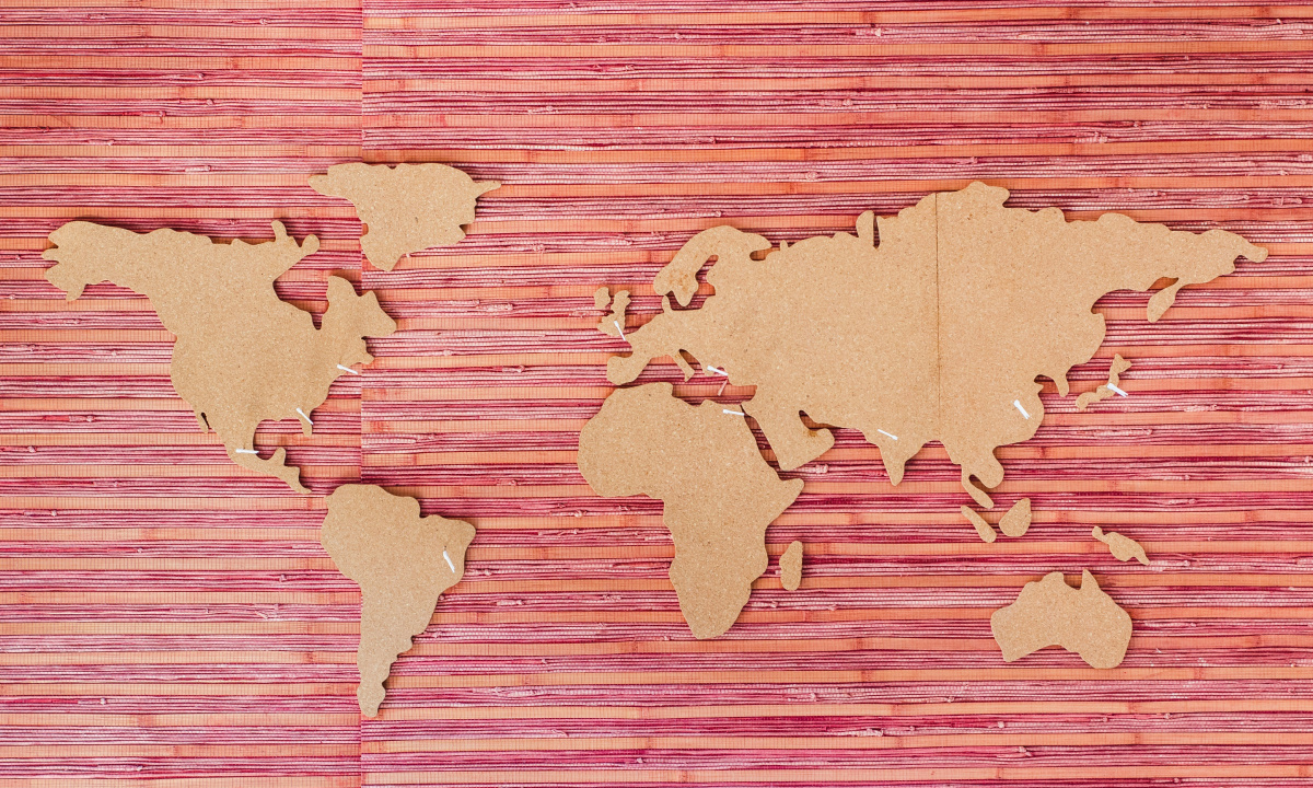 Meet bibu's new International Selection Committee A world map with the continents cut out of cardboard, lying on a pink paper