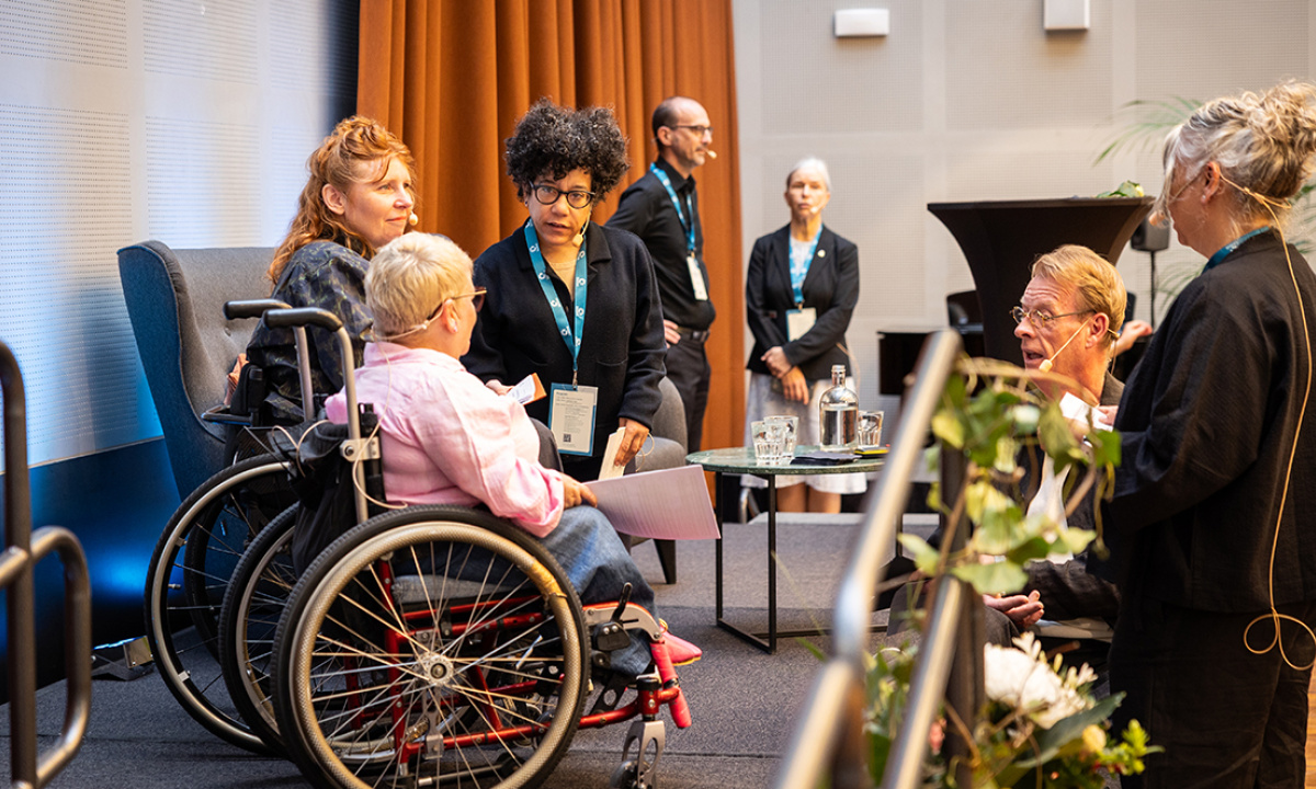 Konstnärer med funktionsvariationer i samtal på en scen