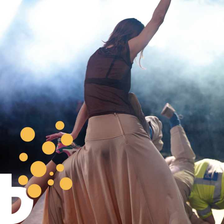 En dansare sedd bakifrån med ena armen i luften