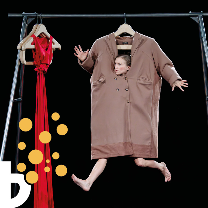 En kvinna hänger från en klädställning omsluten av en stor rock